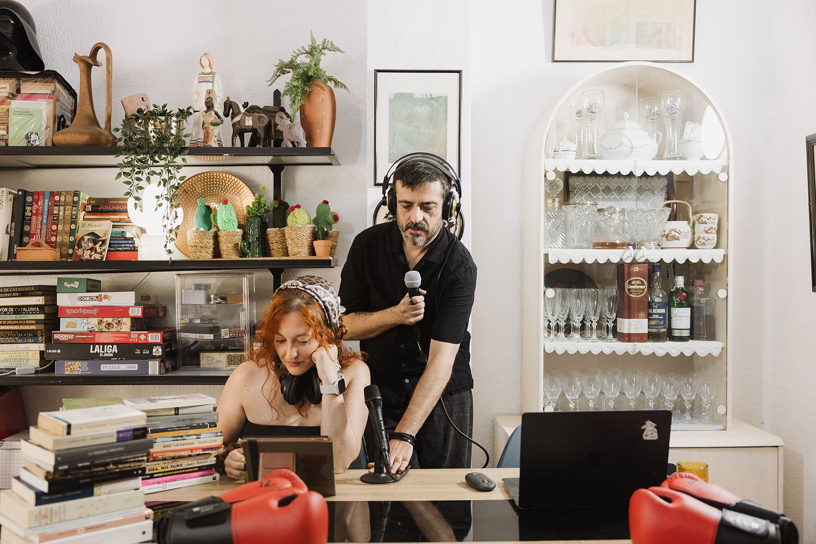 Núria y Toni grabando un episodio de El Doble Gancho, con guantes de boxeo sobre la mesa y pilas de libros